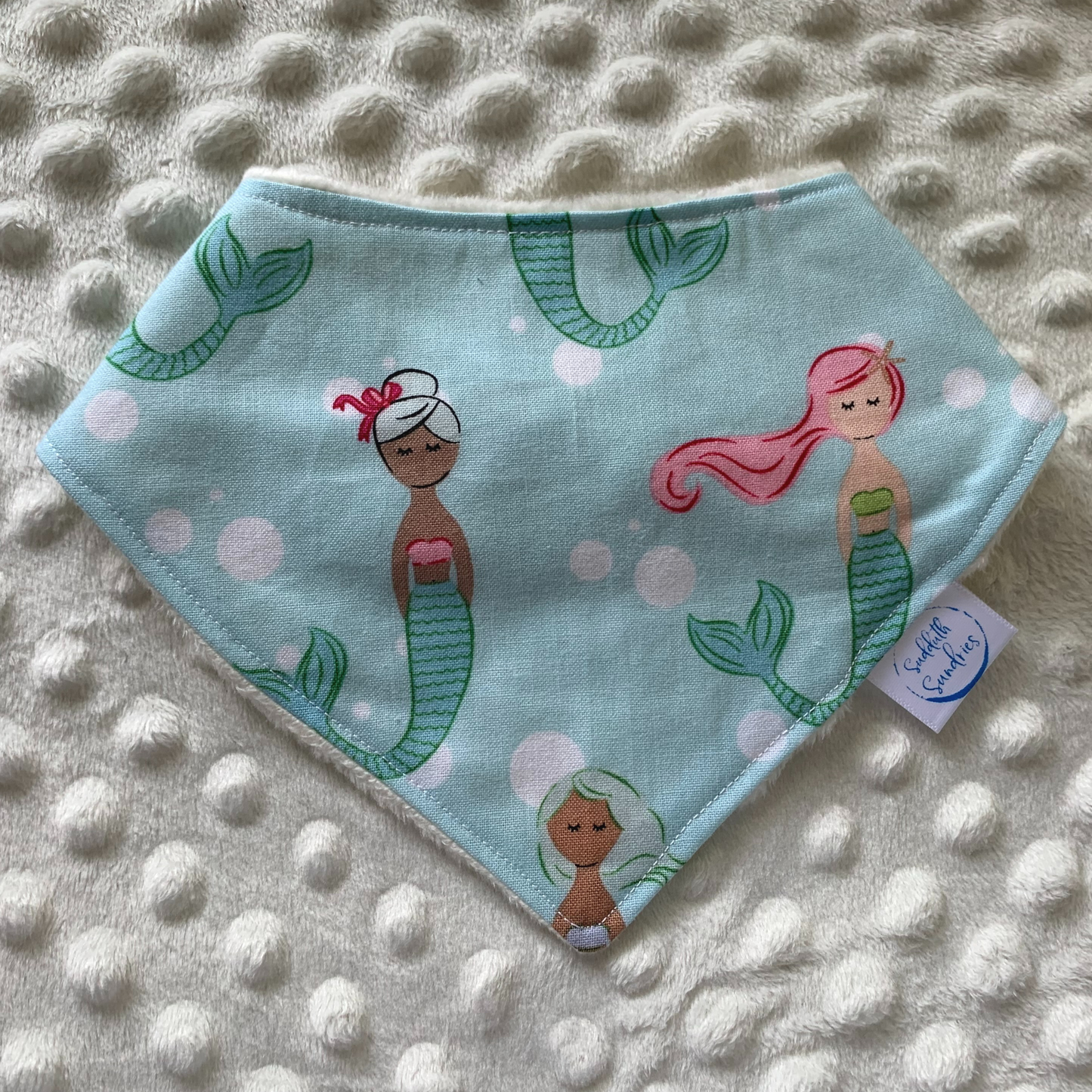 Are you having or attending a mermaid baby shower? Or an under the sea first birthday party?! I love the colorful mermaids featured on this bib!